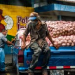 Guy looks over truck full of onions in El Salvador.